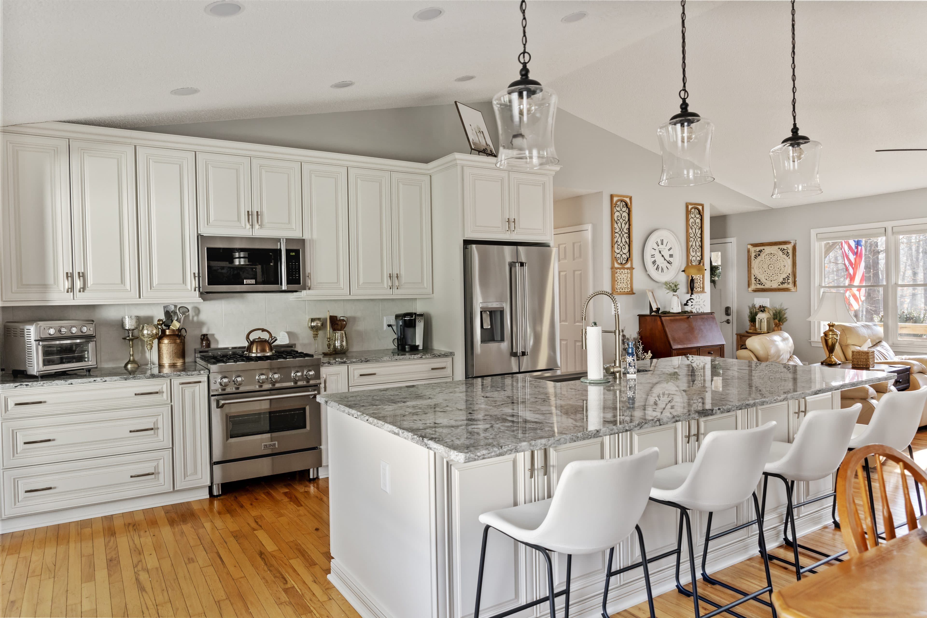 Open-plan kitchen renovation with a granite island and vaulted ceiling, built by 5 Stones Renovation