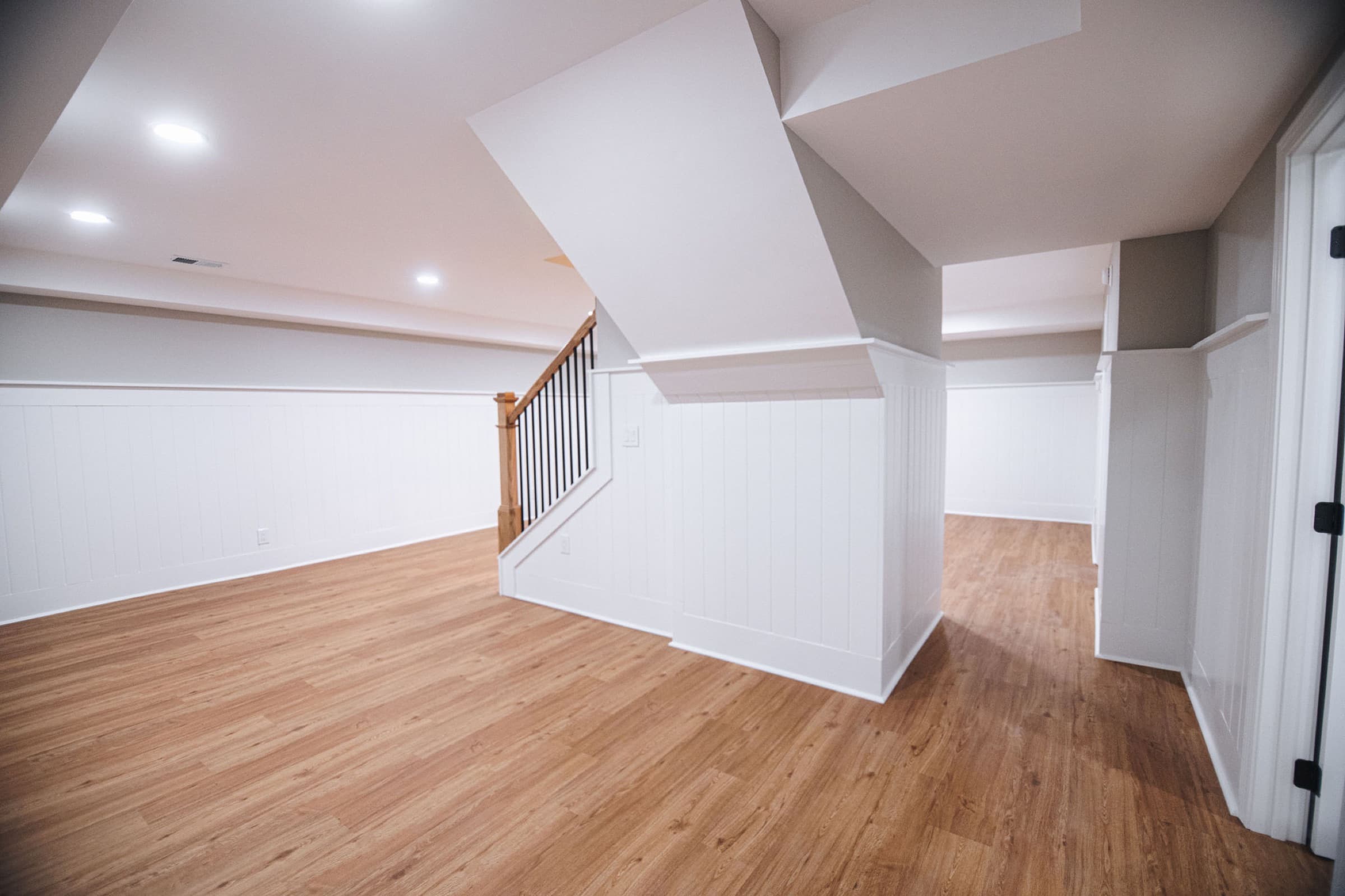 Ball Ground basement remodel — finished living area with board-and-batten wainscoting and stair railing