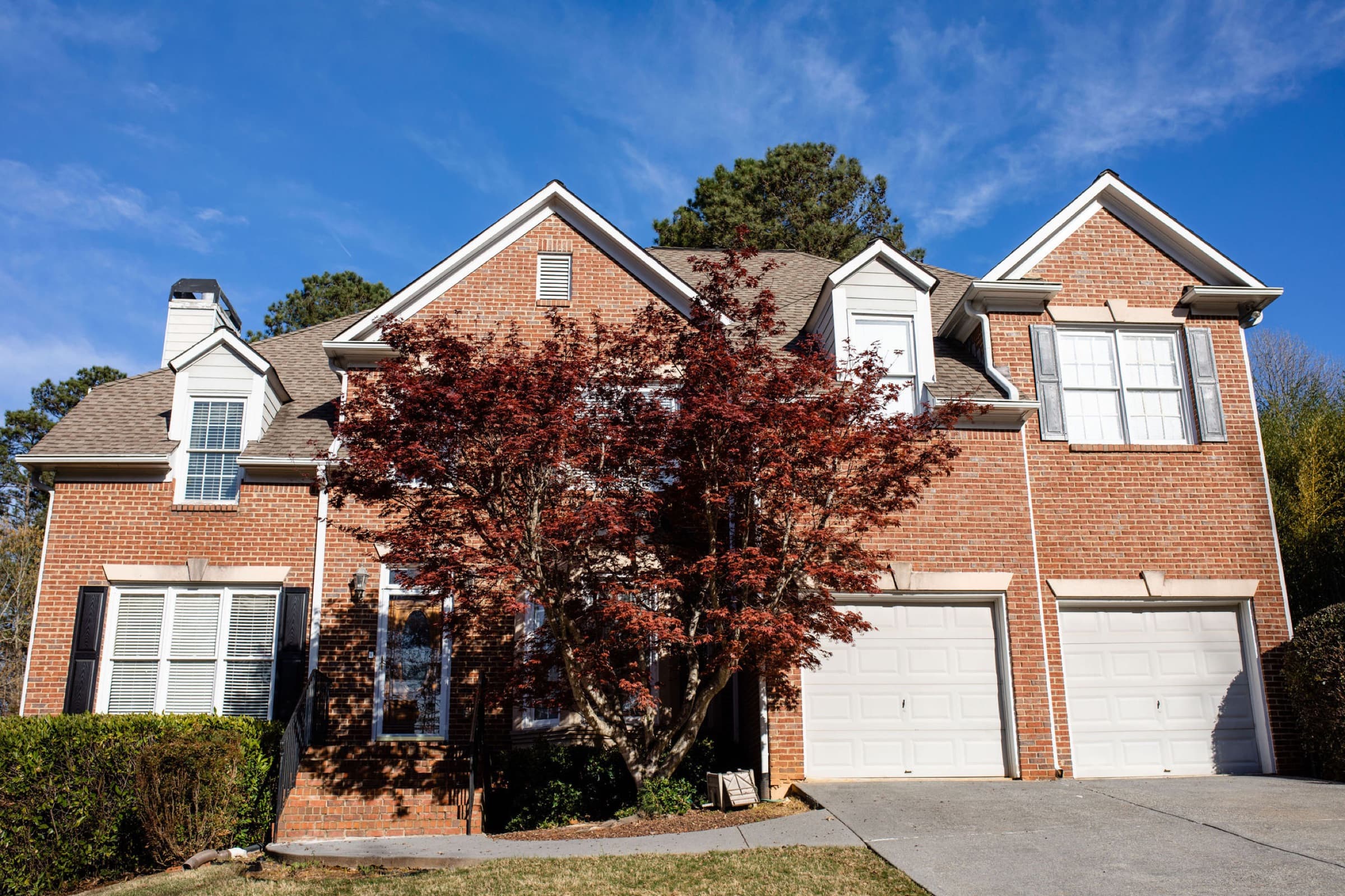 Bridgemill home exterior before repaint — tan trim and dark shutters