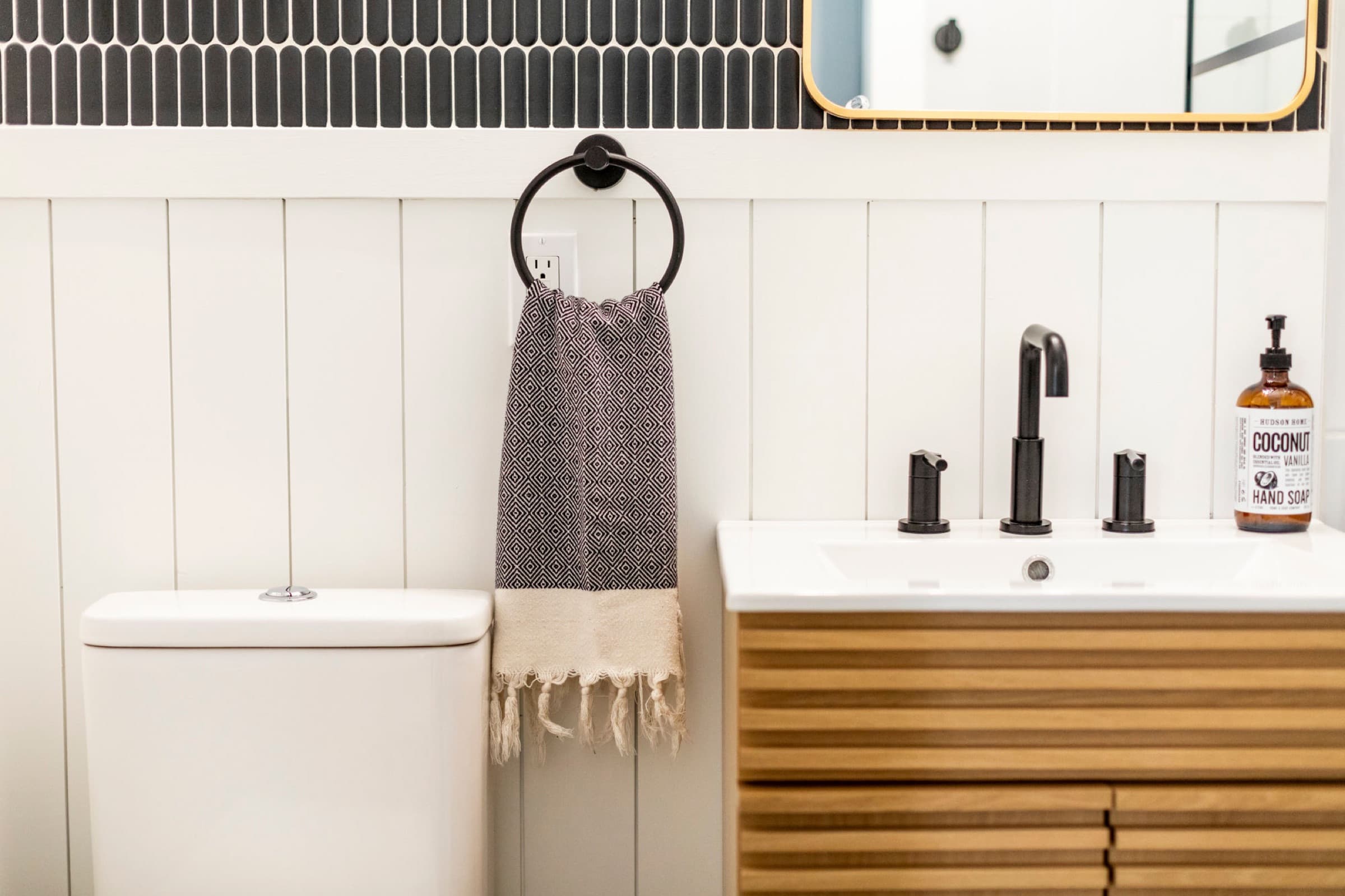 Candlestick Ct downstairs bathroom — toilet and vanity with brass faucet detail