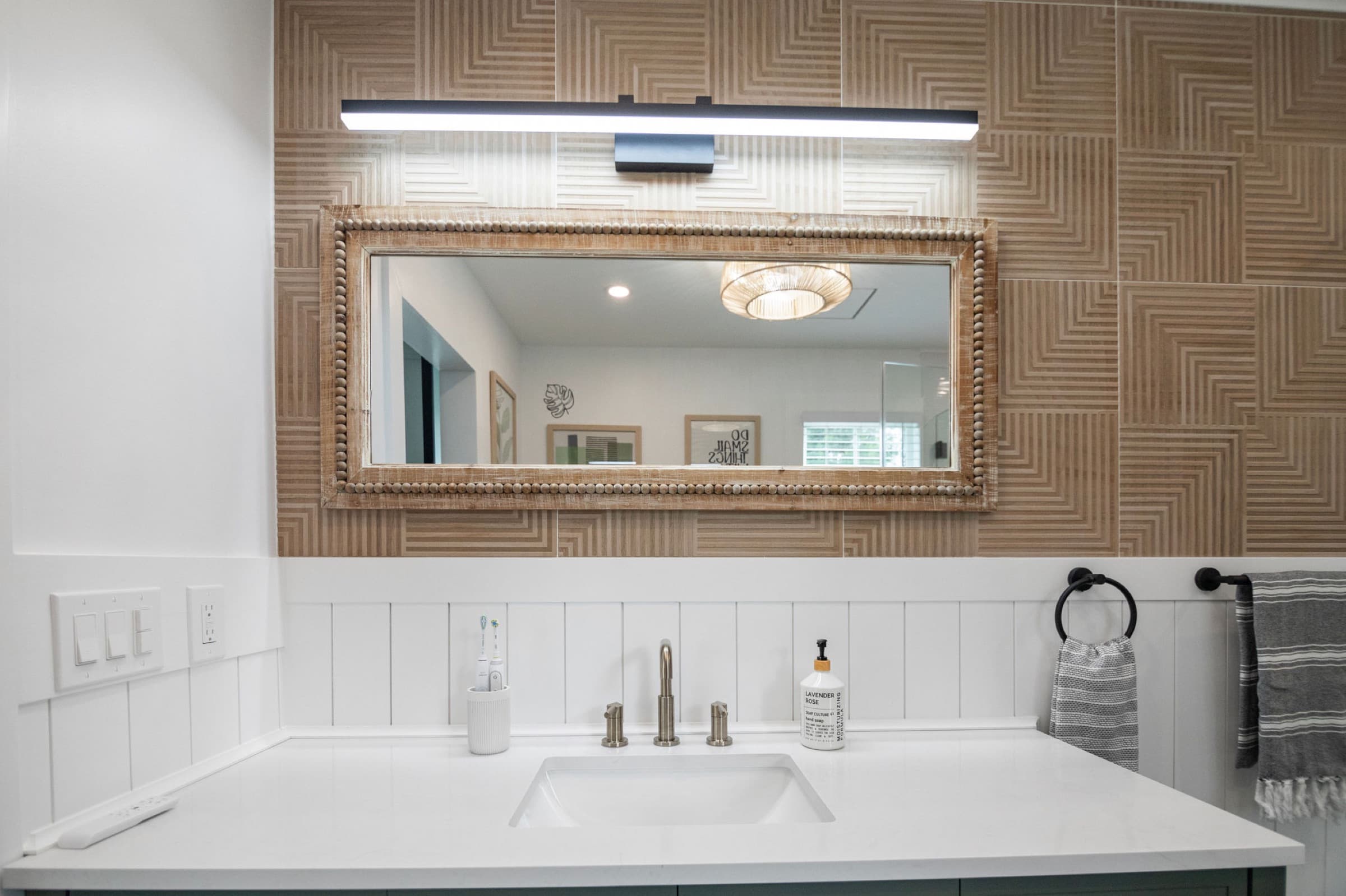 Candlestick Ct primary bathroom — vanity mirror and brass sconce lighting detail