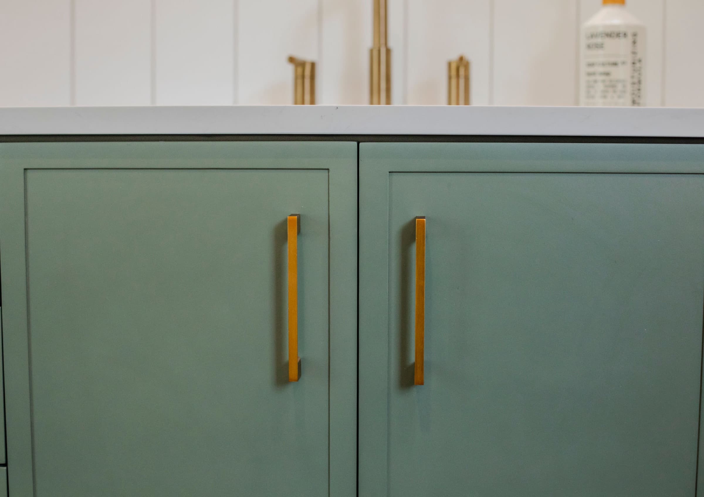 Candlestick Ct primary bathroom — sage green cabinetry detail with brass pulls
