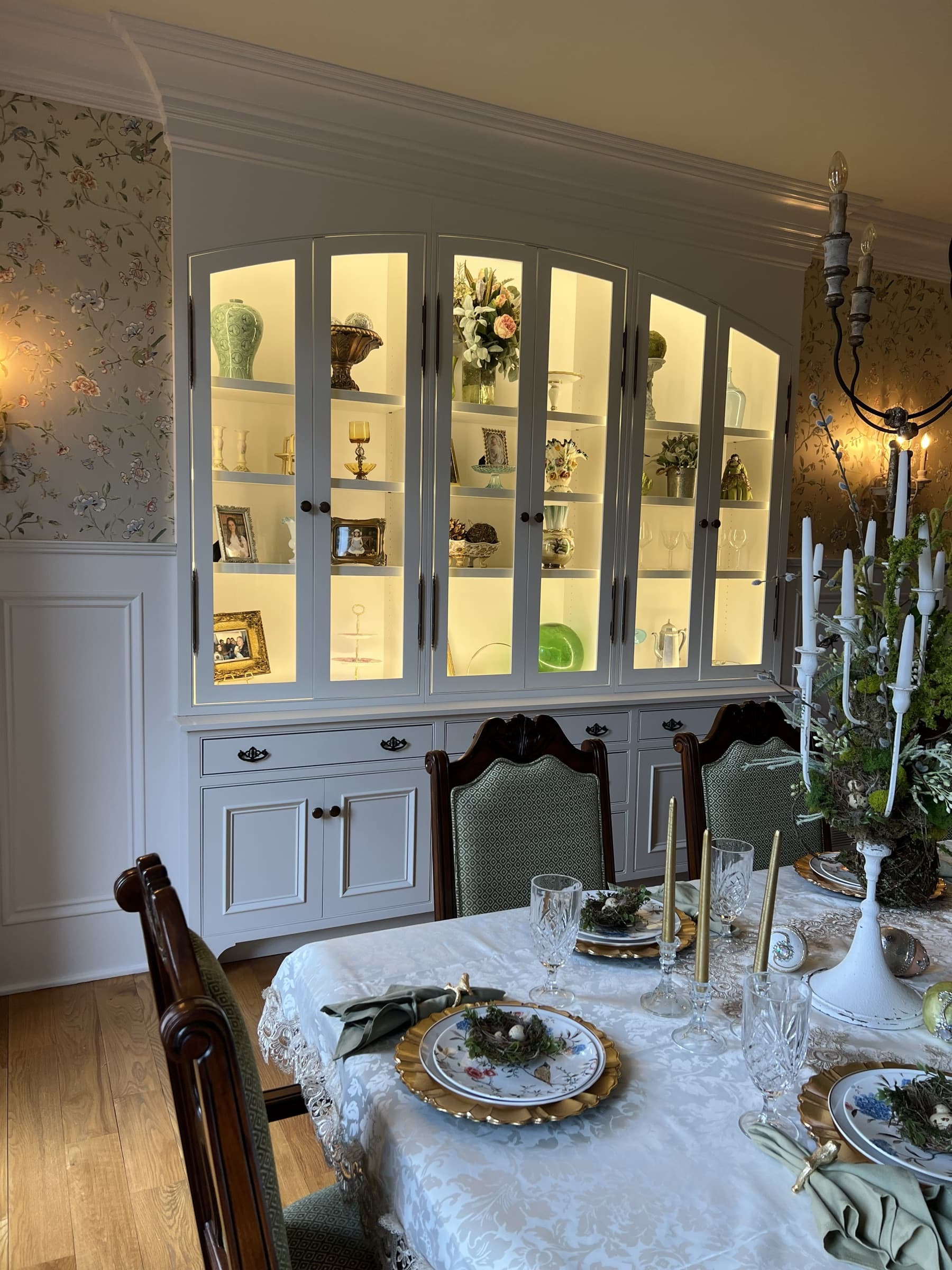 Custom dining room china cabinet — illuminated shelving styled with decor