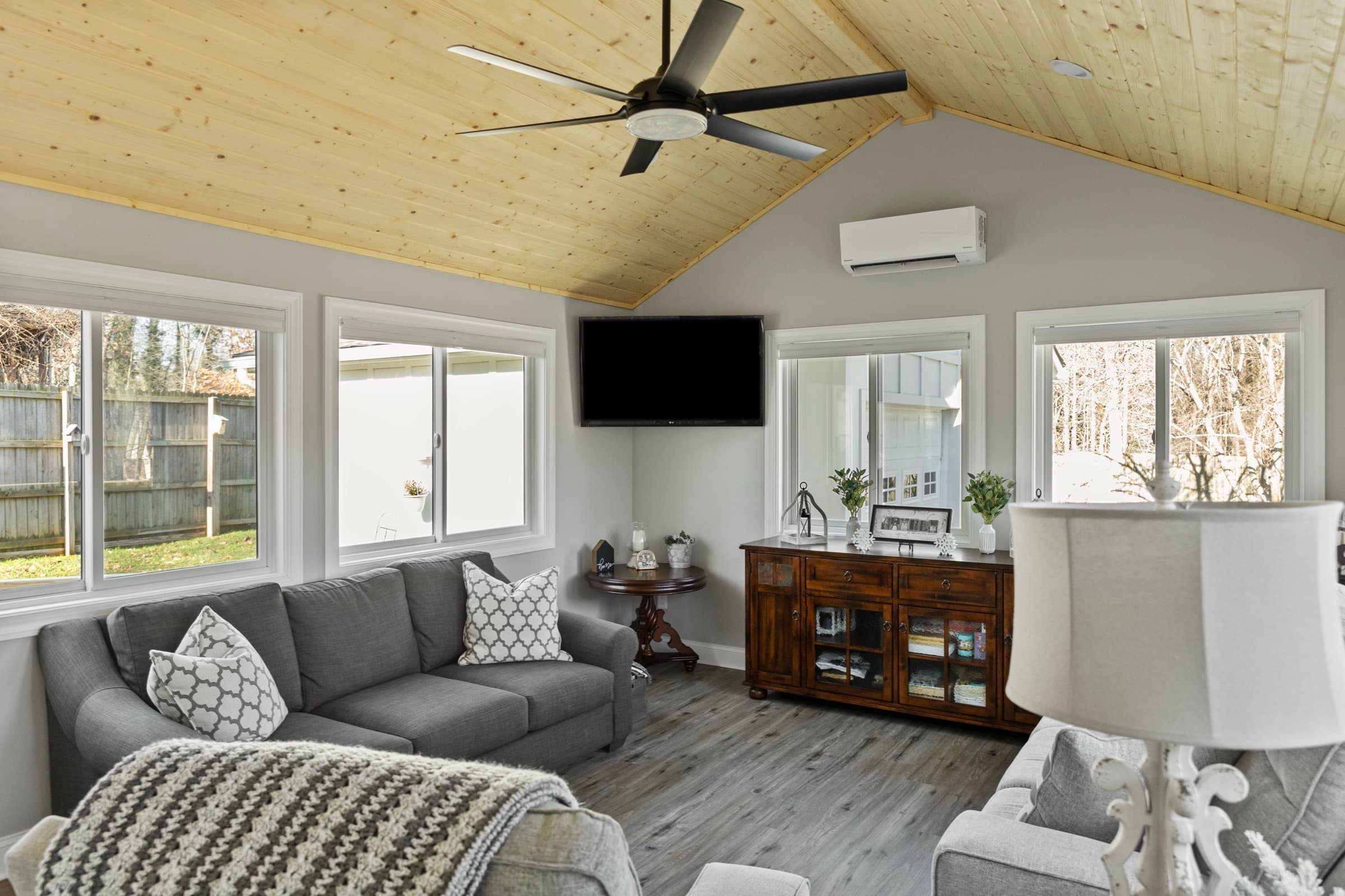 Galts Ferry sunroom addition — sectional seating, mounted TV, and mini-split