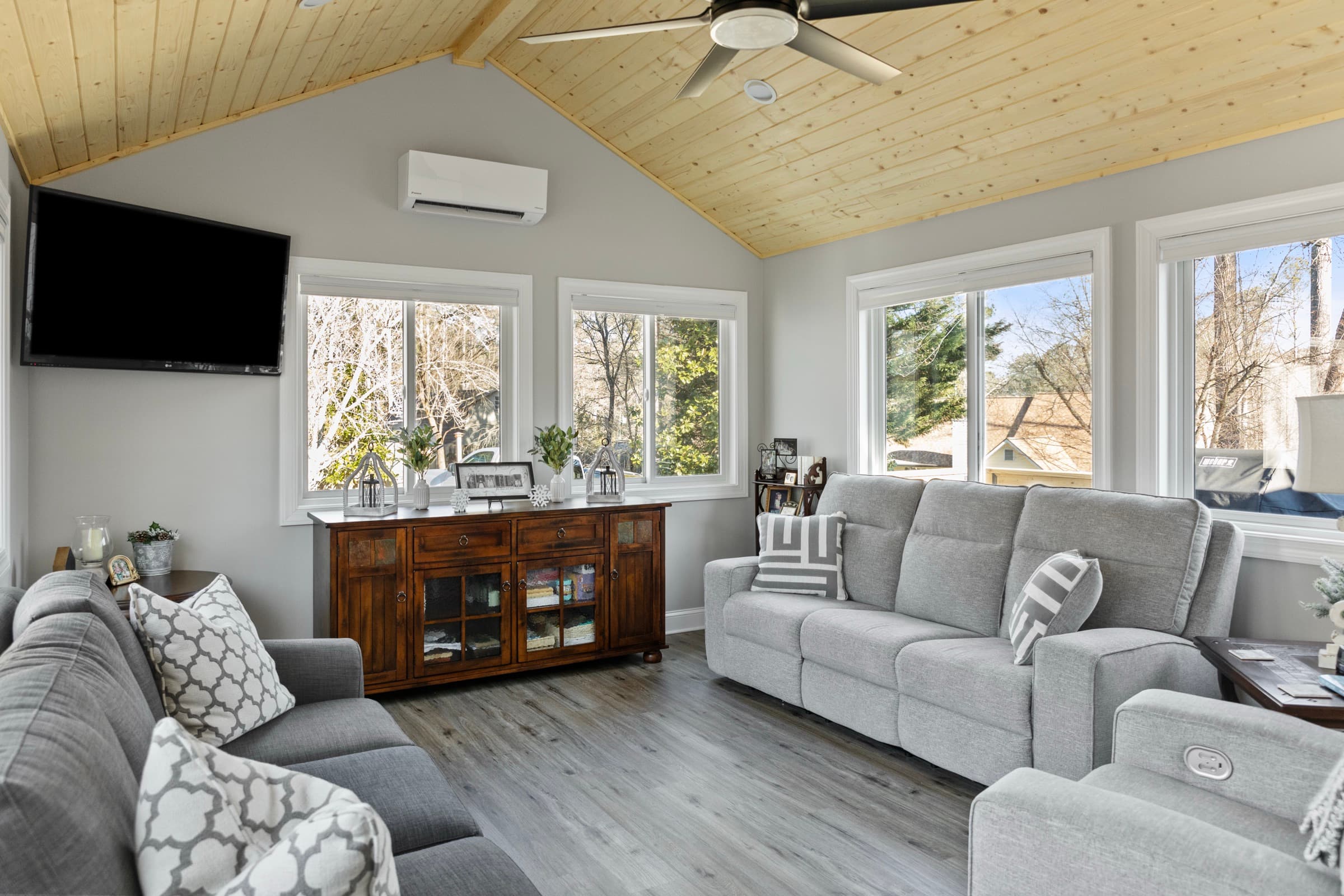 Galts Ferry sunroom addition — sectional seating, TV, and mini-split with view to driveway