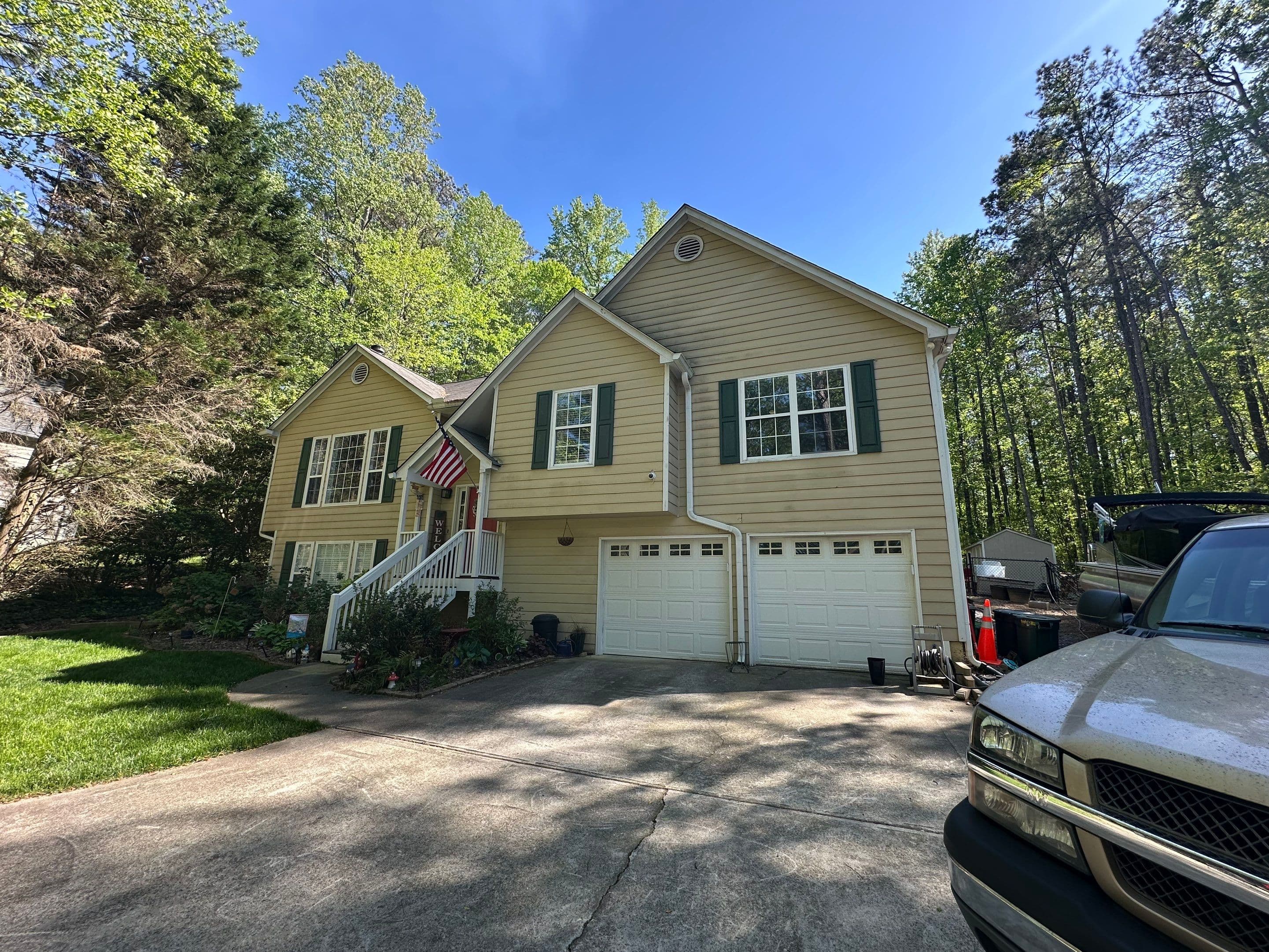 37 Maddox Rd exterior before renovation — original tan siding and white garage doors