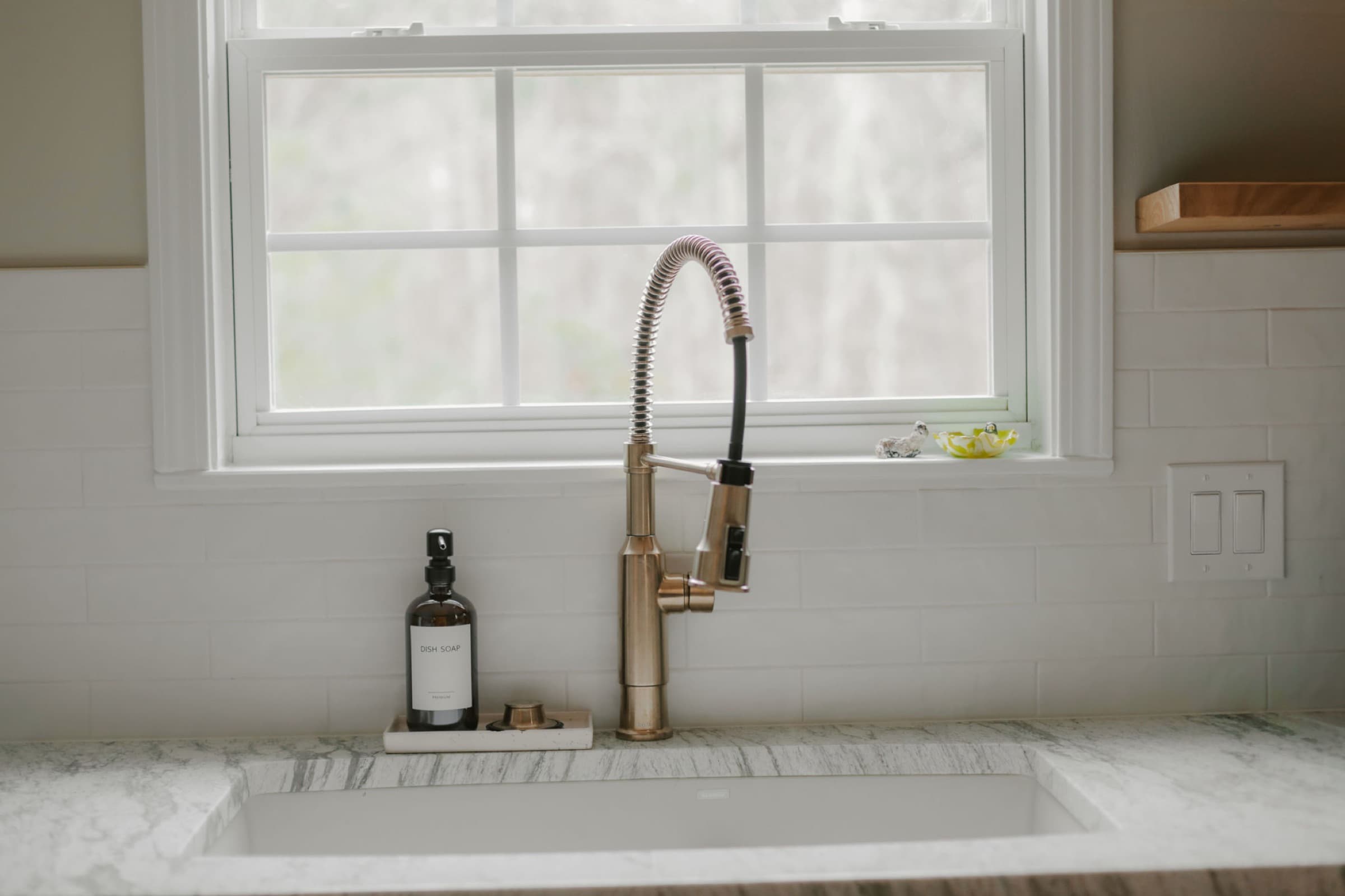Powder Springs kitchen remodel — sink with brass faucet below the window